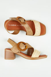A model wearing size 37 of the Meridine Heel in colour Taupe, from the front, showing the whole outfit
