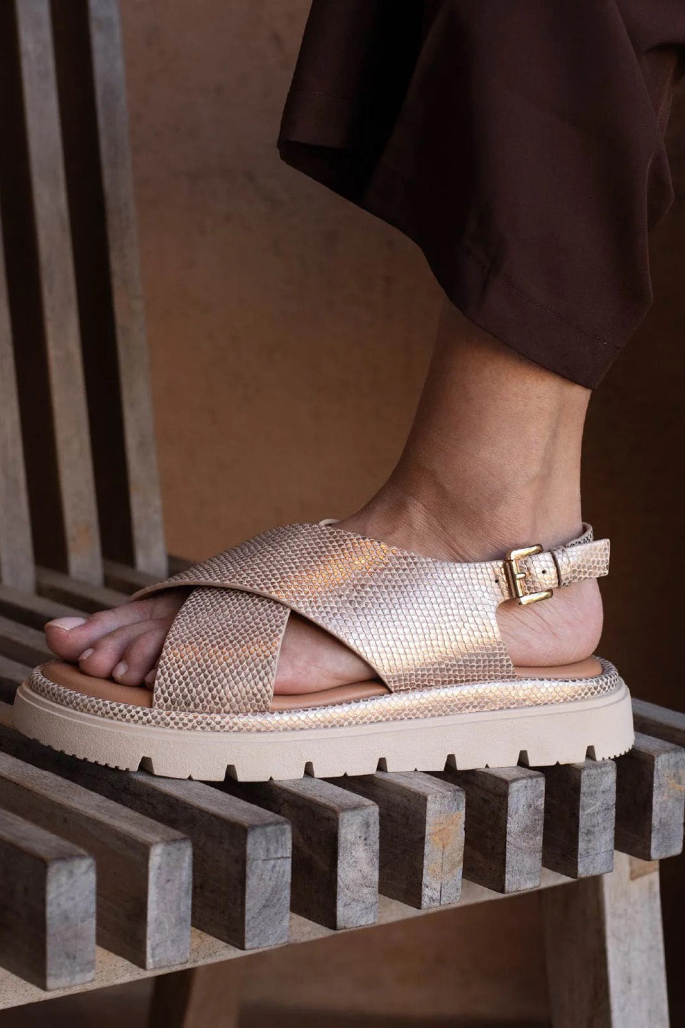 A model wearing the Tolis Flatform Sandal in colour Beigelizar (Metallics), from the front, showing the whole outfit
