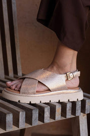 A model wearing the Tolis Flatform Sandal in colour Beigelizar (Metallics), from the front, showing the whole outfit
