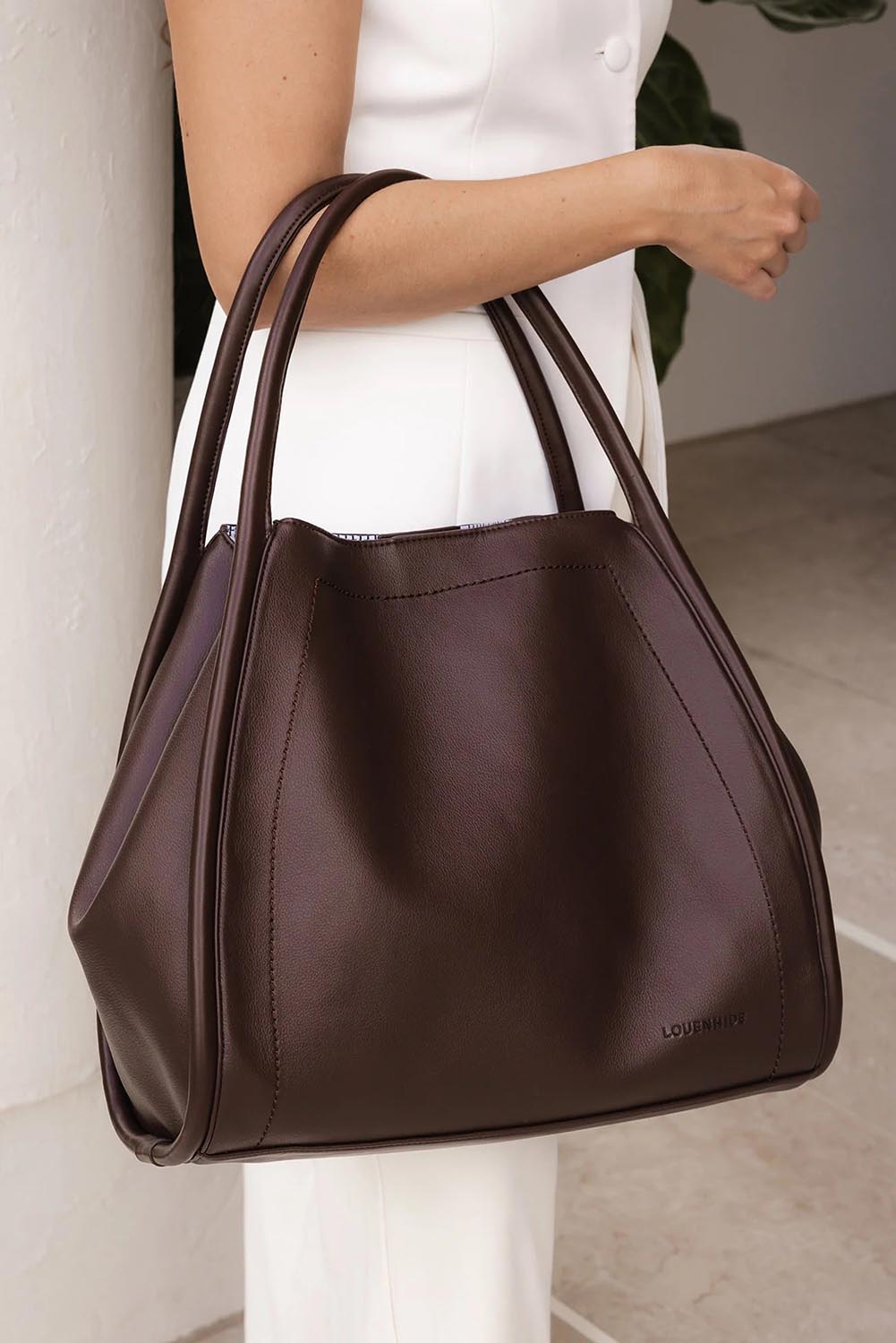 A model wearing the Sutton Shoulder Bag in colour Chocolate, from the front, showing the whole outfit