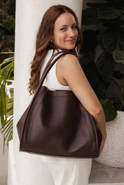 A model wearing the Sutton Shoulder Bag in colour Chocolate, from the front, showing the whole outfit