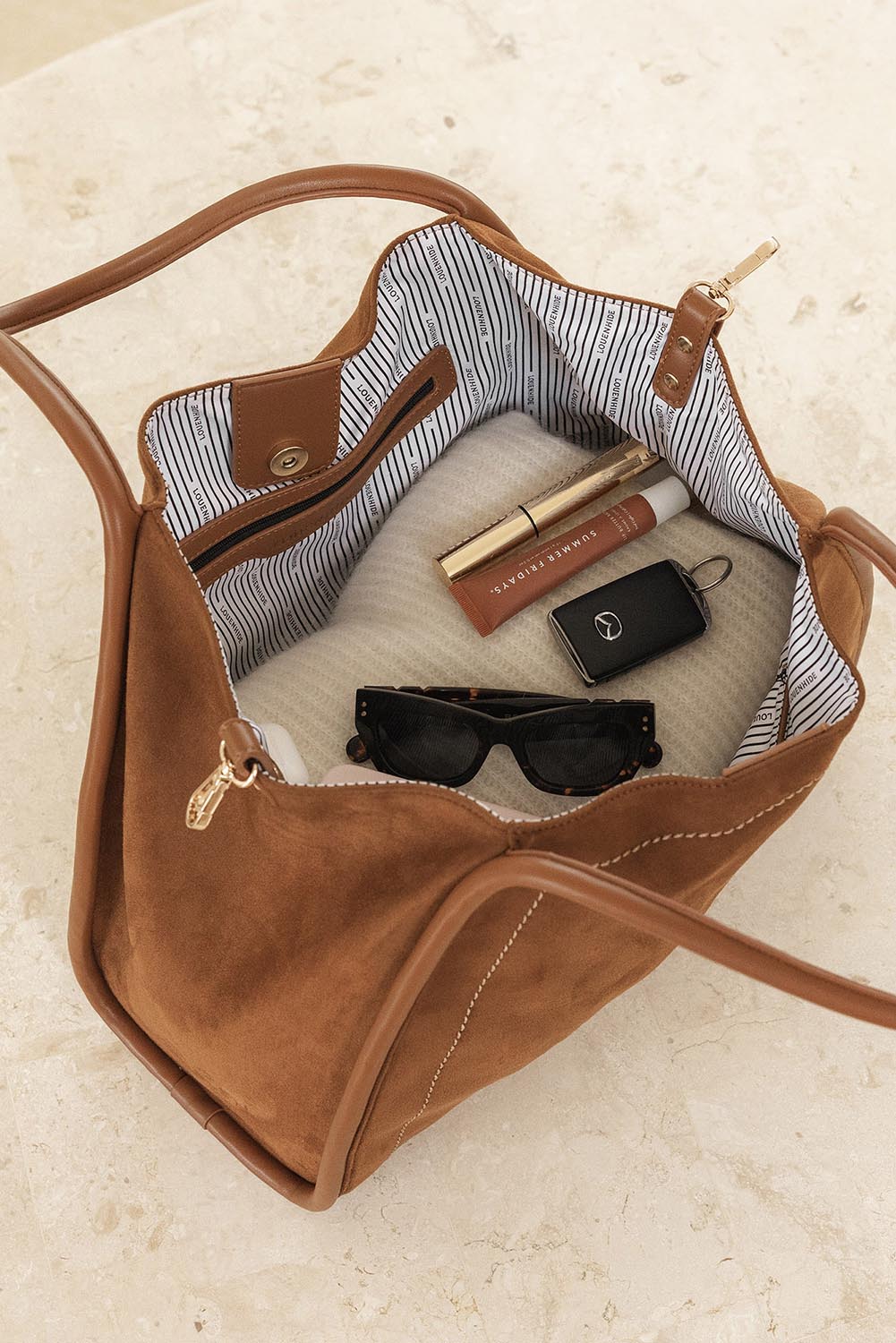 A model wearing the Sutton Shoulder Bag in colour Tansuede, from the front, showing the whole outfit