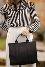 A model wearing the Manhattan Tote Bag in colour Black (Black), from the front, showing the whole outfit