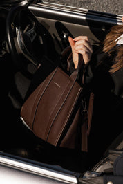 A model wearing the Manhattan Tote Bag in colour Chocolate, from the front, showing the whole outfit