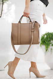 A model wearing the Manhattan Tote Bag in colour Coffee, from the front, showing the whole outfit