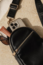 A model wearing the Bella Sling Bag in colour Black (Black), from the front, showing the whole outfit