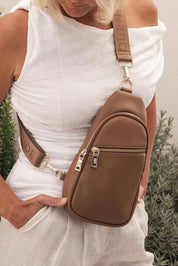 A model wearing the Bella Sling Bag in colour Caramel, from the front, showing the whole outfit