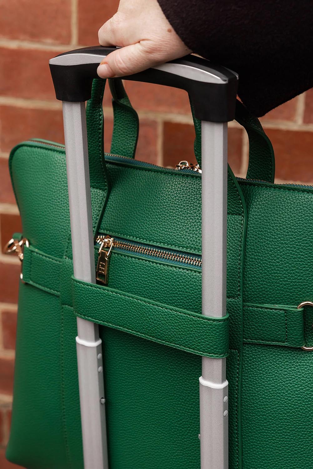 A model wearing the Rhodes Laptop Bag in colour Green (Green), from the front, showing the whole outfit