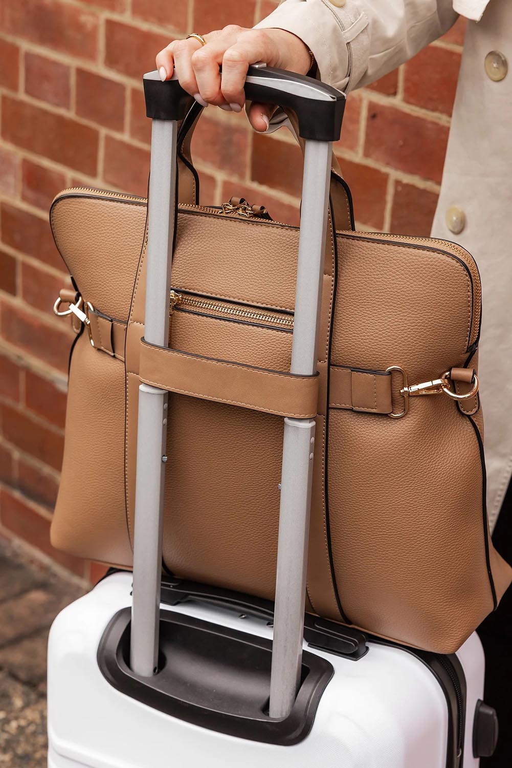 A model wearing the Rhodes Laptop Bag in colour Latte, from the front, showing the whole outfit