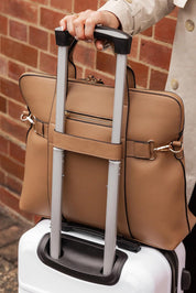A model wearing the Rhodes Laptop Bag in colour Latte, from the front, showing the whole outfit