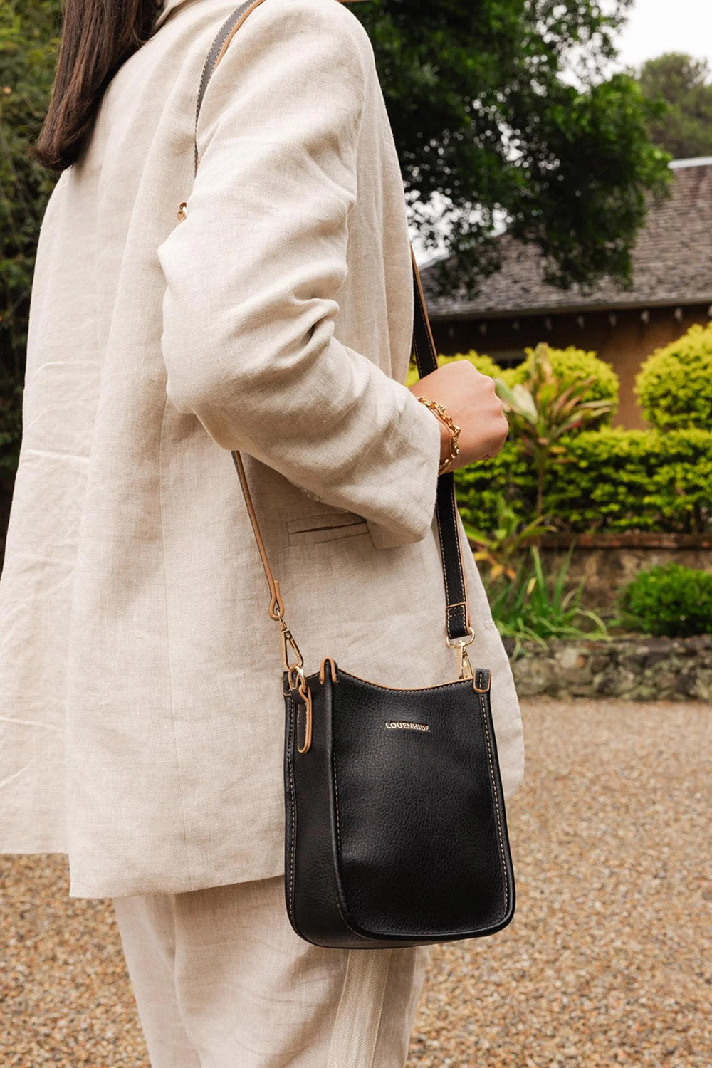 A model wearing the Parker Phone Crossbody Bag in colour Black (Black), from the front, showing the whole outfit