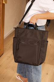 A model wearing the Bronx Backpack in colour Nylonchoc, from the front, showing the whole outfit