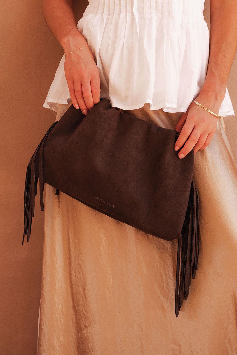 A model wearing the Reese Shoulder Bag in colour Chocolate, from the front, showing the whole outfit