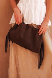 A model wearing the Reese Shoulder Bag in colour Chocolate, from the front, showing the whole outfit