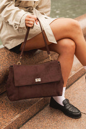 A model wearing the Arden Suedette Shoulder Bag in colour Chocolate, from the front, showing the whole outfit