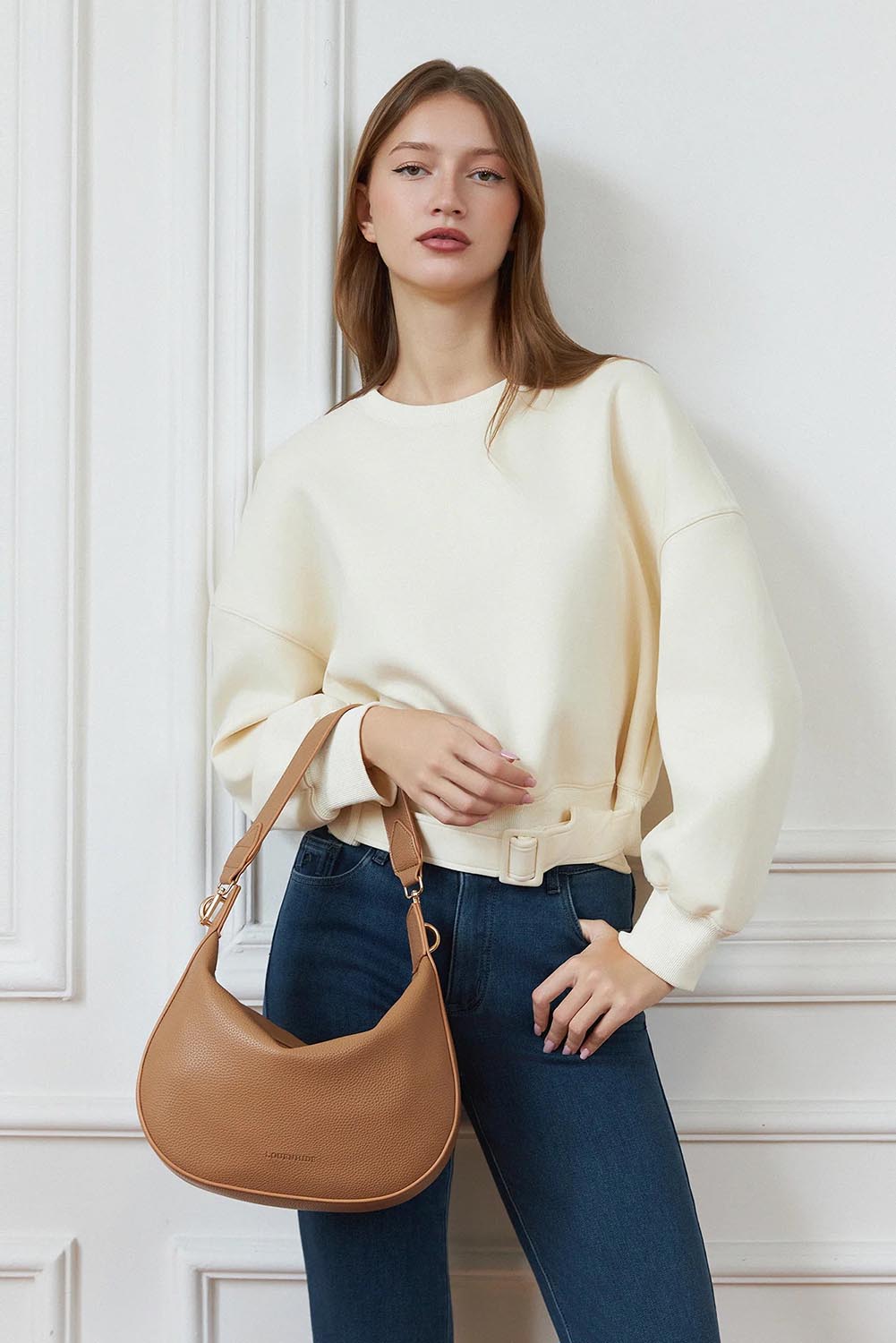 A model wearing the Georgina Shoulder Bag in colour Honey, from the front, showing the whole outfit
