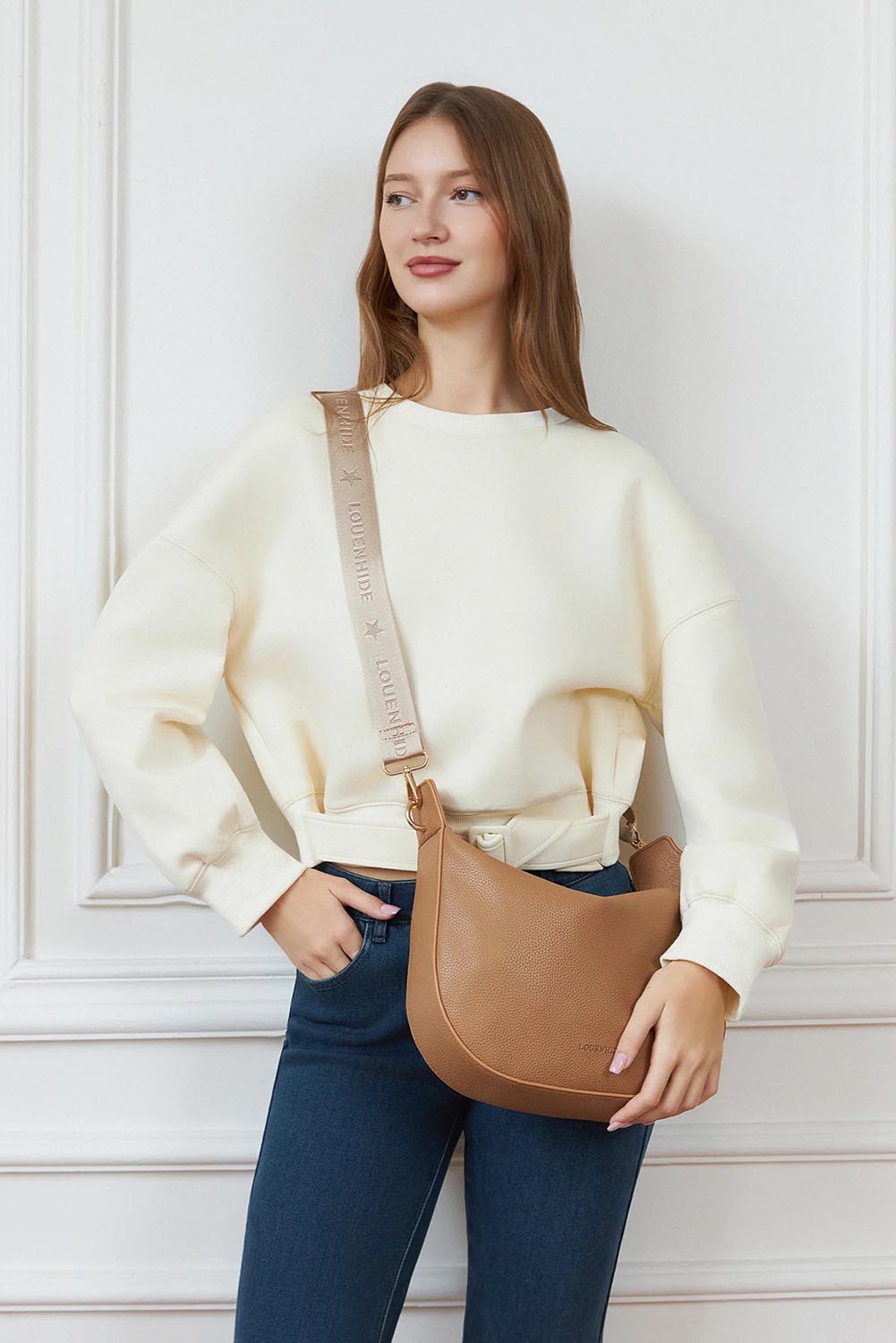 A model wearing the Georgina Shoulder Bag in colour Honey, from the front, showing the whole outfit