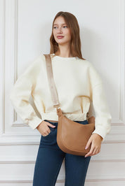 A model wearing the Georgina Shoulder Bag in colour Honey, from the front, showing the whole outfit