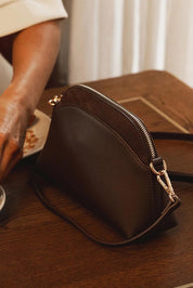 A model wearing the Alison Crossbody Handbag in colour Chocolate, from the front, showing the whole outfit