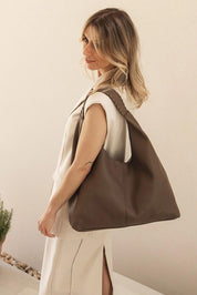 A model wearing the Avery Shoulder Bag in colour Mocha, from the front, showing the whole outfit