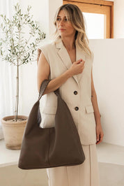 A model wearing the Avery Shoulder Bag in colour Mocha, from the front, showing the whole outfit