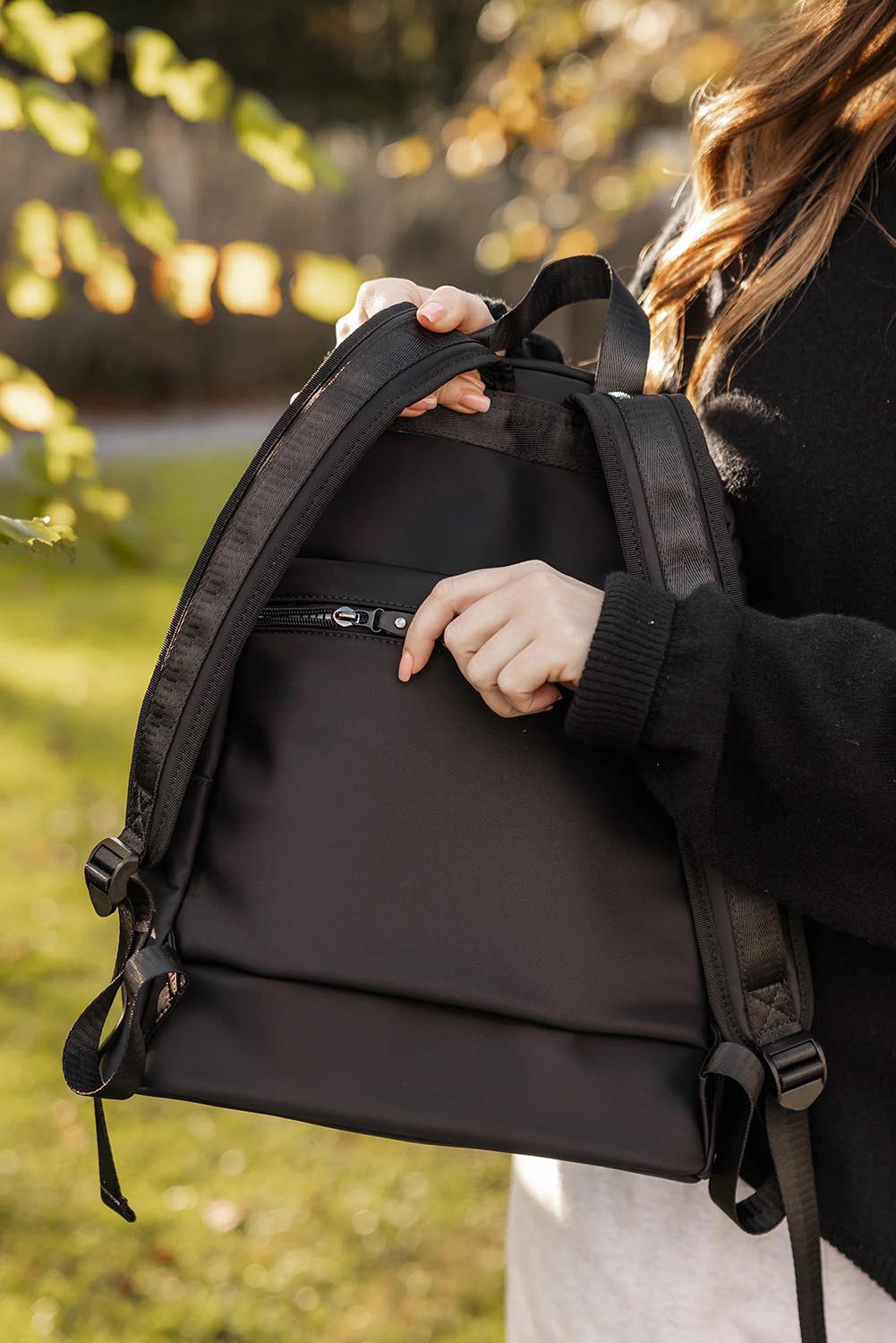 A model wearing the Carter Backpack in colour Black (Black), from the front, showing the whole outfit