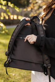 A model wearing the Carter Backpack in colour Black (Black), from the front, showing the whole outfit