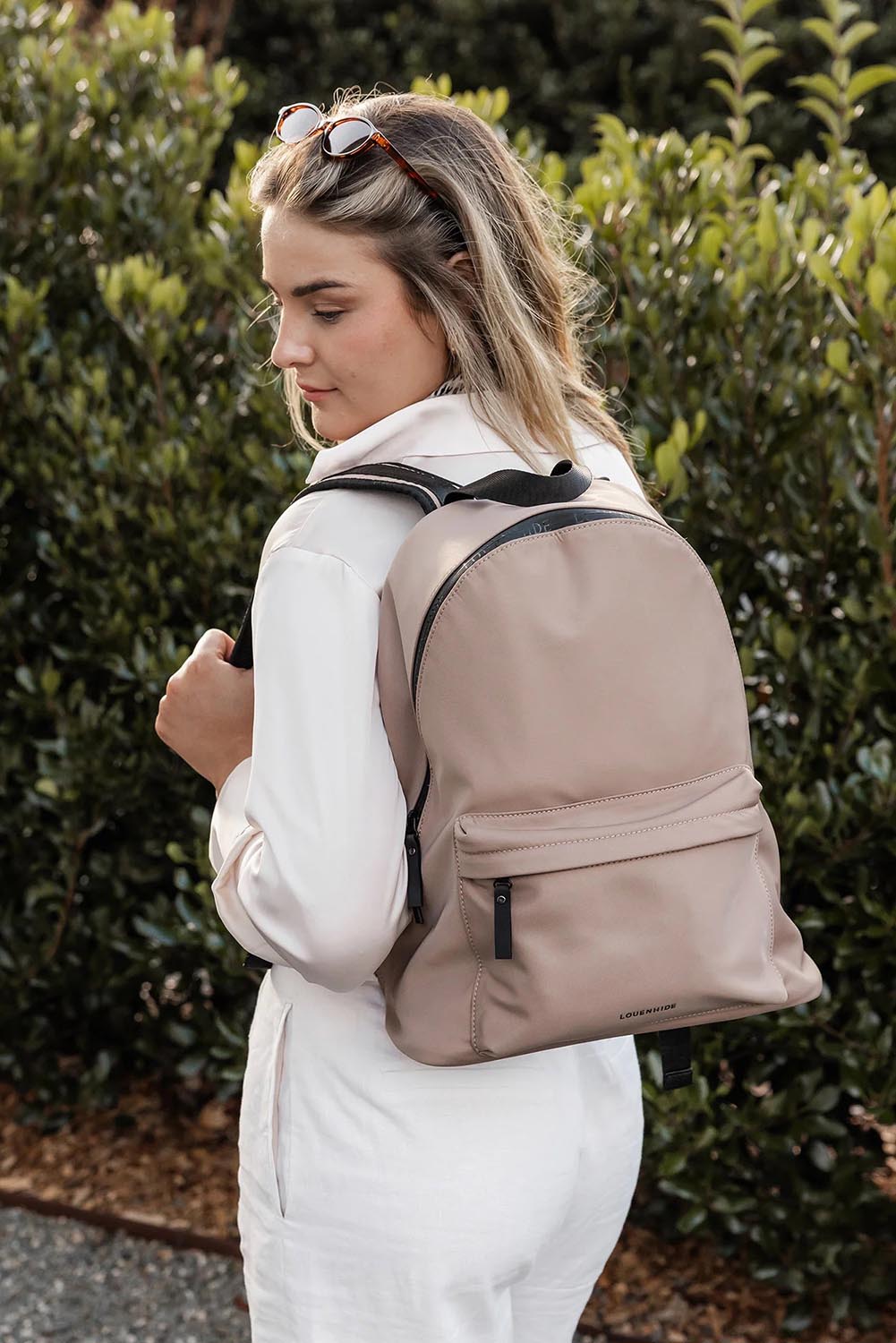 A model wearing the Carter Backpack in colour Mocha, from the front, showing the whole outfit