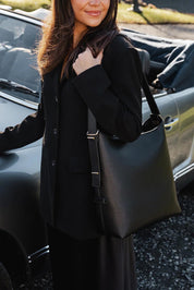A model wearing the Audrey Shoulder Bag in colour Black (Black), from the front, showing the whole outfit