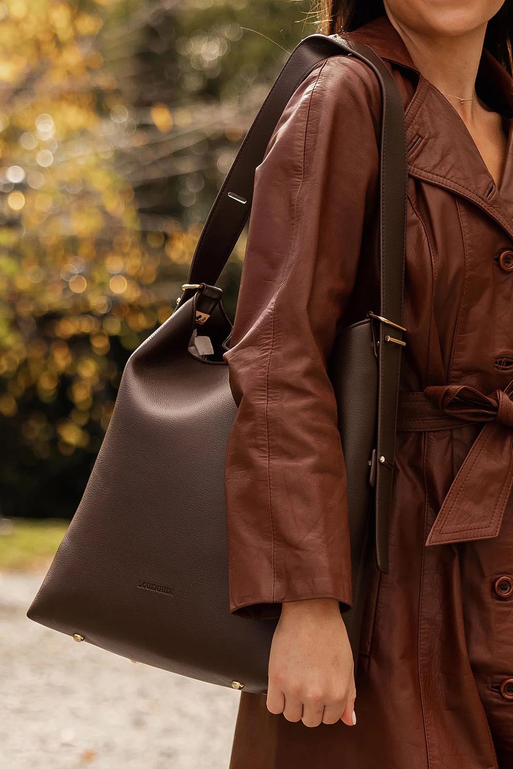 A model wearing the Audrey Shoulder Bag in colour Chocolate, from the front, showing the whole outfit