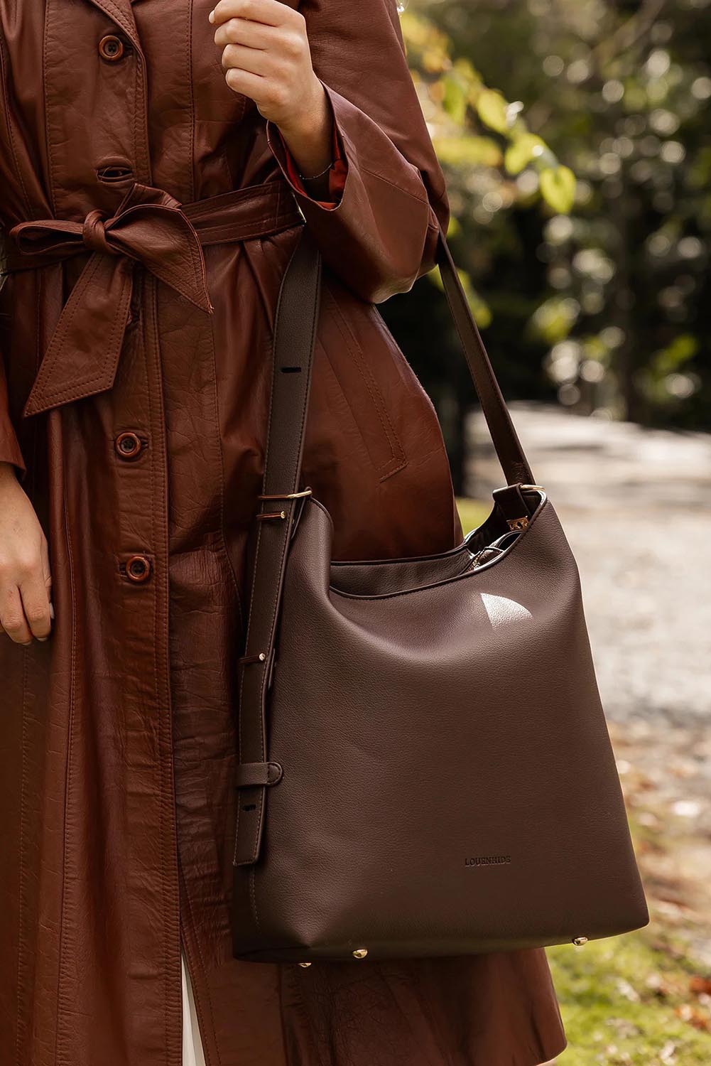 A model wearing the Audrey Shoulder Bag in colour Chocolate, from the front, showing the whole outfit