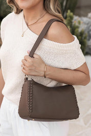 A model wearing the Dana Shoulder Bag in colour Mocha, from the front, showing the whole outfit