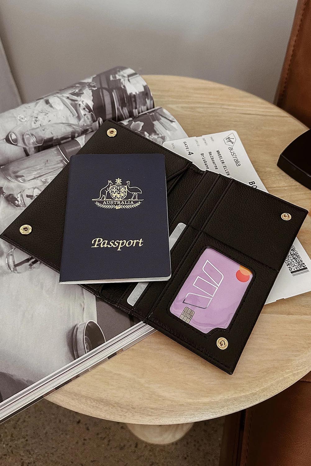 A model wearing the Venice Passport Wallet in colour Black (Black), from the front, showing the whole outfit