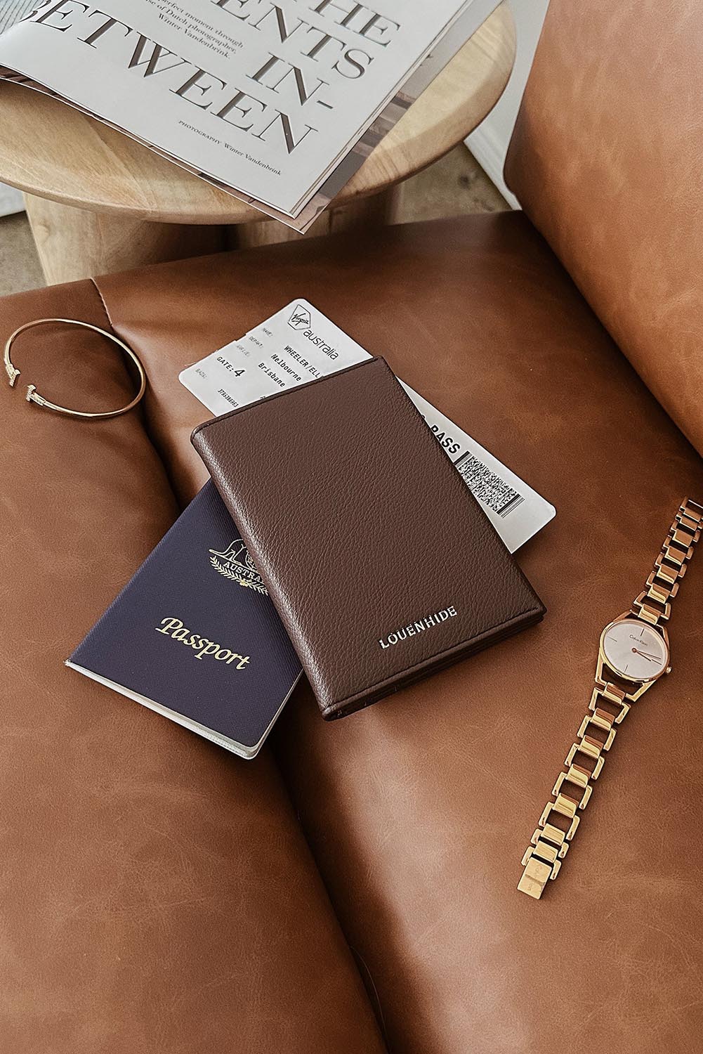 A model wearing the Venice Passport Wallet in colour Chocolate, from the front, showing the whole outfit