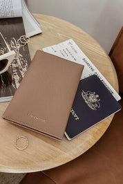 A model wearing the Venice Passport Wallet in colour Mocha, from the front, showing the whole outfit