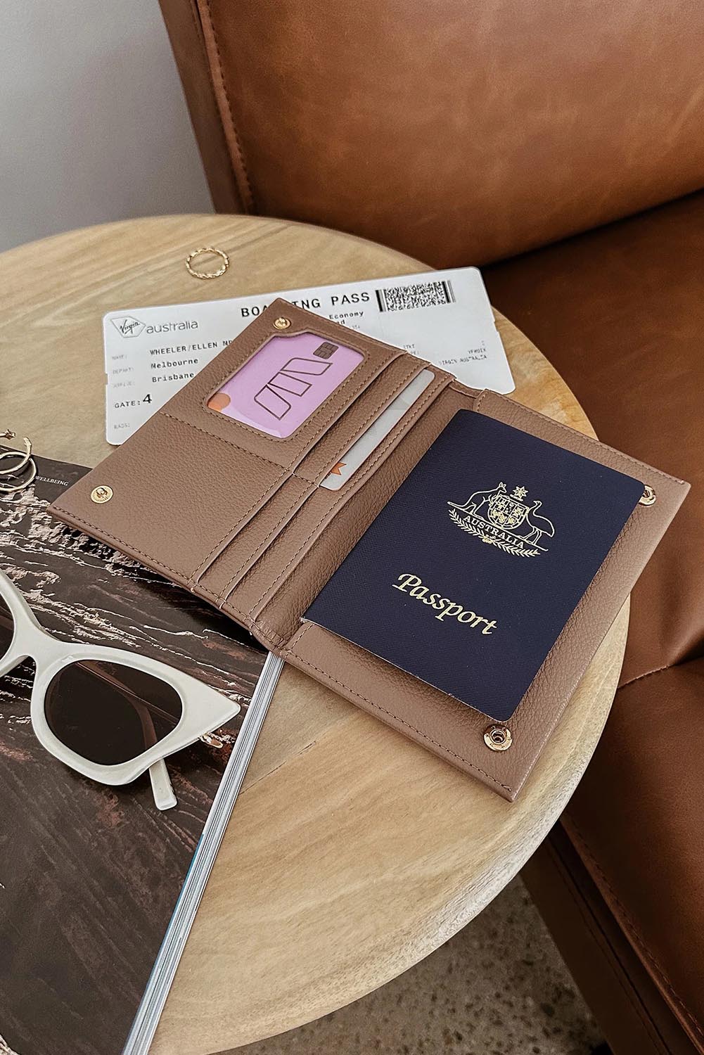 A model wearing the Venice Passport Wallet in colour Mocha, from the front, showing the whole outfit