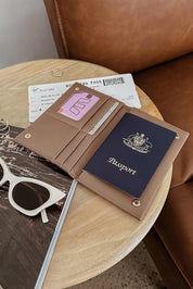 A model wearing the Venice Passport Wallet in colour Mocha, from the front, showing the whole outfit