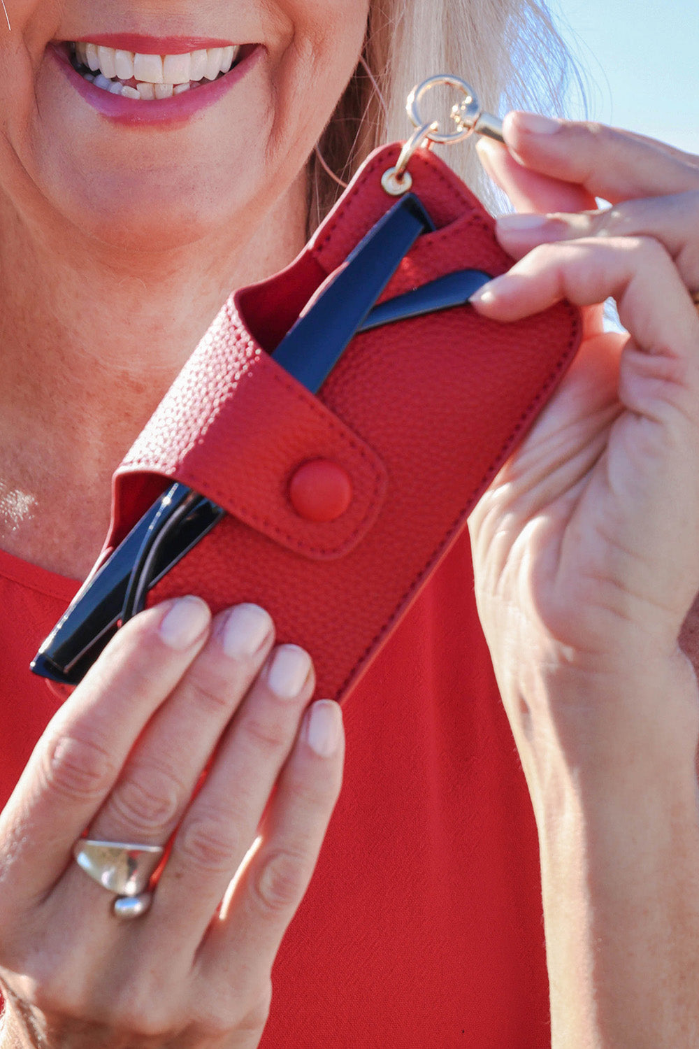 A model wearing the Skittle Sunglass Case in colour Red (Red), from the front, showing the whole outfit
