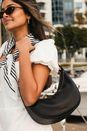 A model wearing the Corfu Handbag in colour Black (Black), from the front, showing the whole outfit