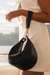 A model wearing the Corfu Handbag in colour Black (Black), from the front, showing the whole outfit