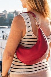 A model wearing the Corfu Handbag in colour Red (Red), from the front, showing the whole outfit