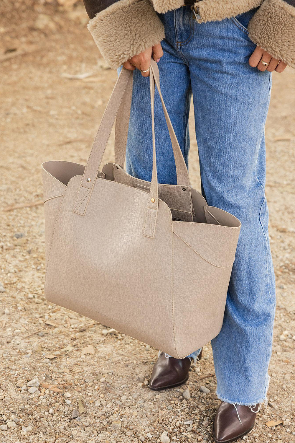 A model wearing the Parisian Shopper Bag in colour Stone, from the front, showing the whole outfit
