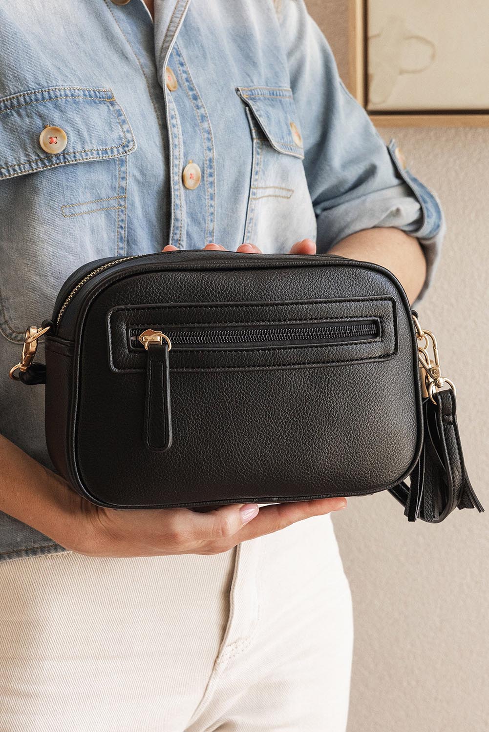 A model wearing the Jacinta Gia Crossbody Bag in colour Black (Black), from the front, showing the whole outfit