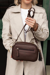 A model wearing the Jacinta Gia Crossbody Bag in colour Chocolate, from the front, showing the whole outfit