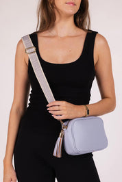 A model wearing the Jacinta Gia Crossbody Bag in colour Cloudblue (Blue), from the front, cropped image