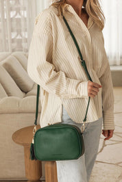 A model wearing the Jacinta Gia Crossbody Bag in colour Forestgrn (Green), from the front, showing the whole outfit