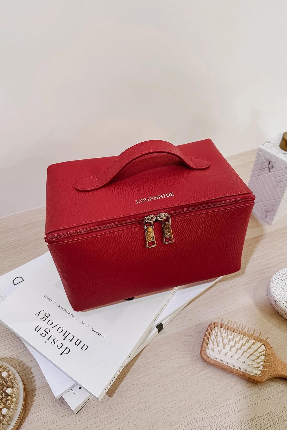 A model wearing the Orion Cosmetic Case in colour Red (Red), from the front, showing the whole outfit