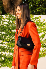 A model wearing the Winona Shoulder Bag in colour Black (Black), from the front, showing the whole outfit