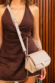 A model wearing the Winona Shoulder Bag in colour Stone, from the front, showing the whole outfit
