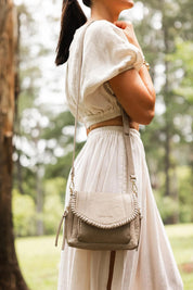 A model wearing the Shania Crossbody Bag in colour Stone, from the front, showing the whole outfit
